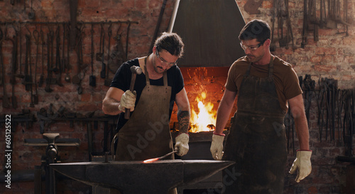 Schilderij op canvas Hammer, anvil and fire with men working in a forge for metal work manufacturing or production