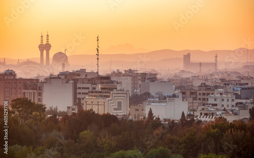 Cityscape and skyline of historical city of Isfahan at sunrise with minarets and domes, mountains on background, Isfahan, Iran. First tourist destination in Iran.