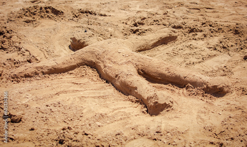 A man made of sand on the beach photo