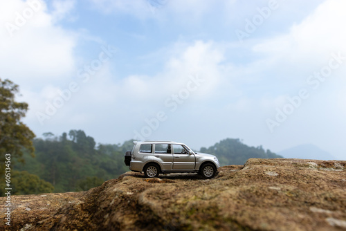 Concept for traveling and adventure. A toy car placed on a giant rock, after some edits. © Figan