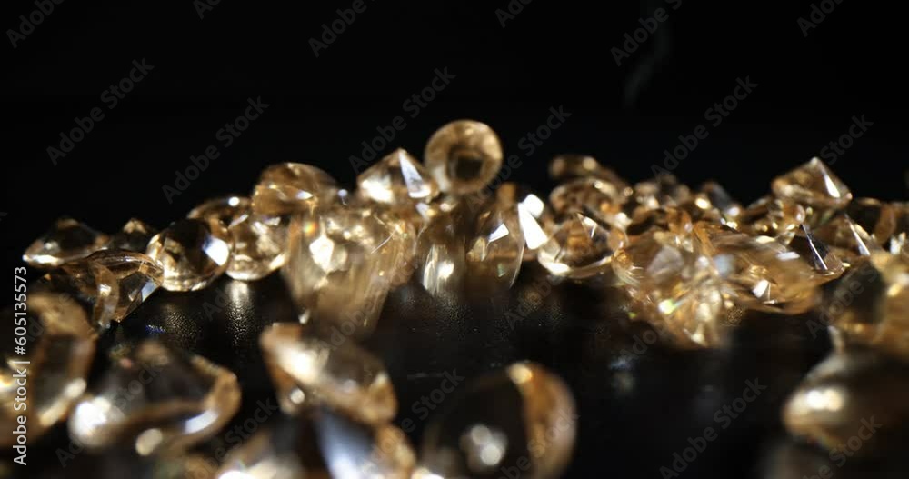 Bright diamonds are thrown on dark table. Luxurious gems for making expensive jewelry on black background Bright diamonds are thrown on dark table. Luxurious gems for making expensive jewelry on black background