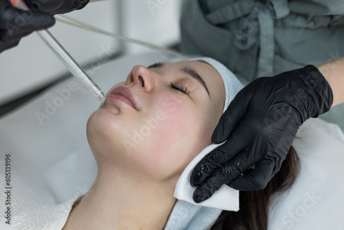 Girl getting oxygen face therapy in a beauty salon. Professional skin care treatment. The unique technology of non-injection oxygen mesotherapy, innovative technique without any painful sensations.