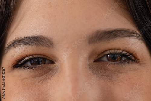 Portrait close up of brown eyes of happy caucasian female customer at hair salon photo