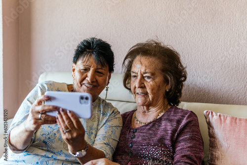 two elderly women with the smartphone taking a photo of themselves photo