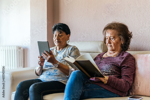 two old women reading with electronic book and paper book photo