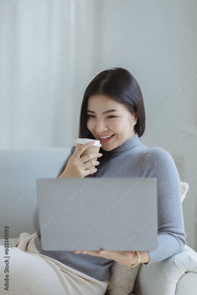 Woman plays on laptop on the sofa in her living room at home, she is resting on weekends after a hard day's work, she relaxes by watching movies and listening to music on her tablet. Holiday concept. Woman plays on laptop on the sofa in her living room at home, she is resting on weekends after a hard day's work, she relaxes by watching movies and listening to music on her tablet. Holiday concept.