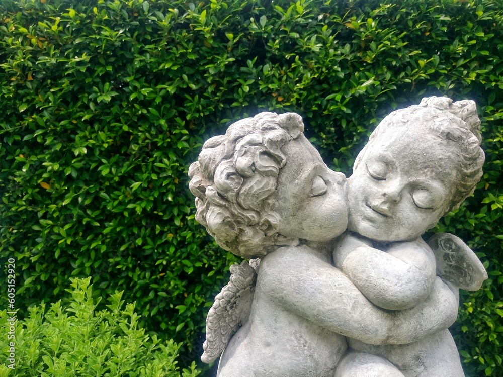 Cupid and Angel statue, Boy's statue kissing girl in garden. Cupid and Angel statue, Boy's statue kissing girl in garden.