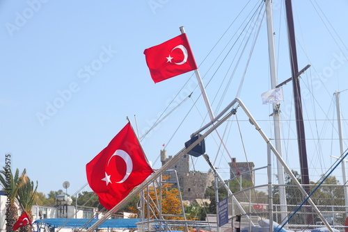 The Turkish flag flies against the backdrop of yachts in the harbor of Bodrum. photo