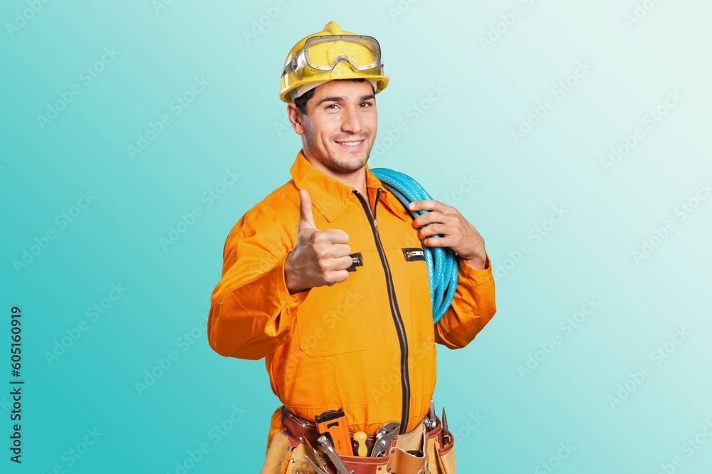 Young electrician man carrying cables posing on background Young electrician man carrying cables posing on background