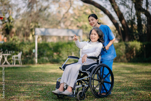 Elderly asian senior woman on wheelchair with Asian careful caregiver.