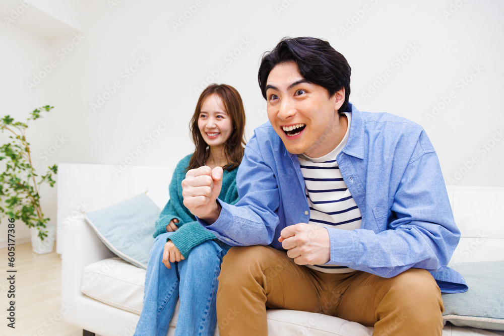 テレビで見ている日本のカップルと応援