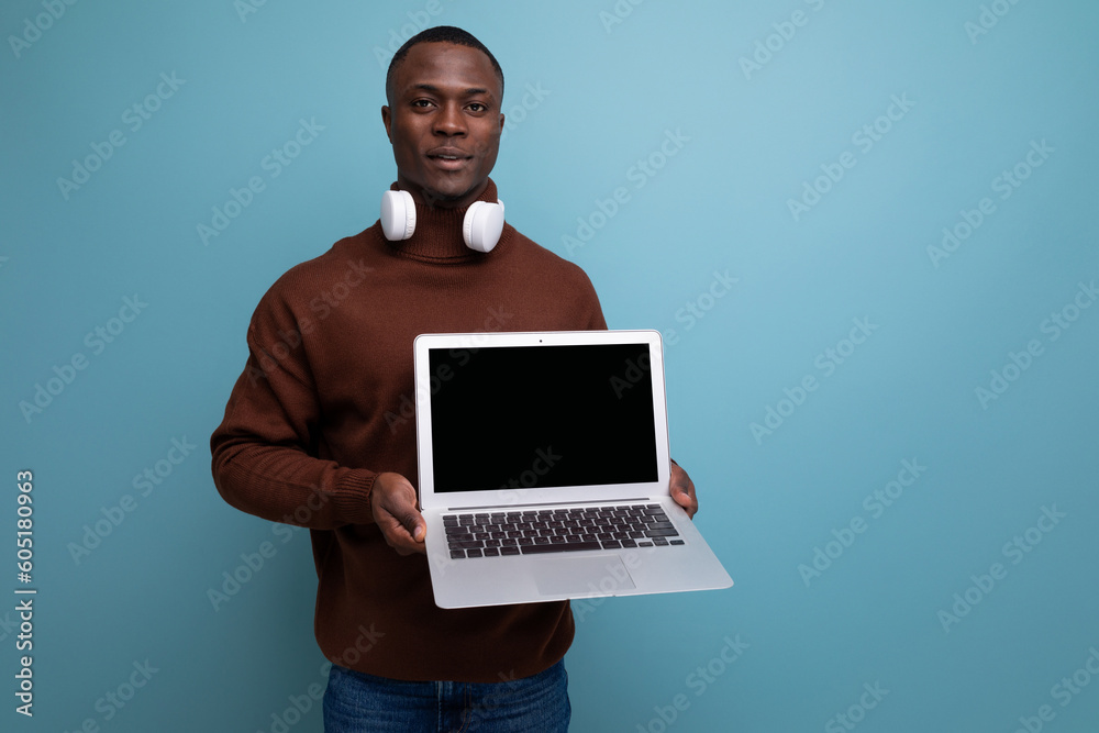 technology store consultant. African man holding a working laptop in his hands