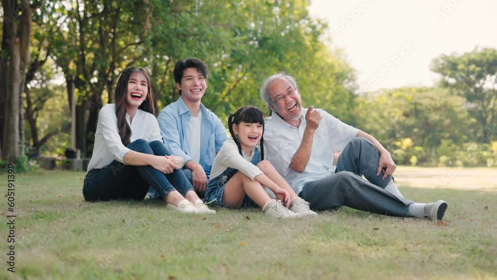Asian family talking and sitting on grass in a park during summer morning, Relax time Asian family talking and sitting on grass in a park during summer morning, Relax time