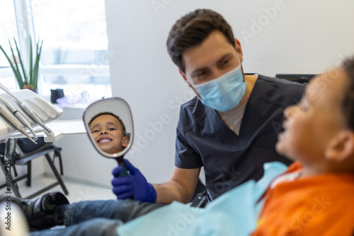 Dark-skinned boy talking to dentist before session