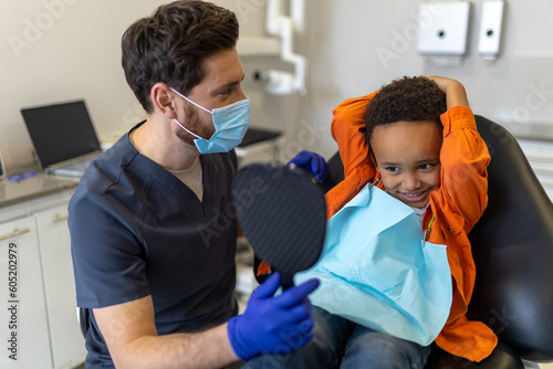 Dark-skinned boy talking to dentist before session