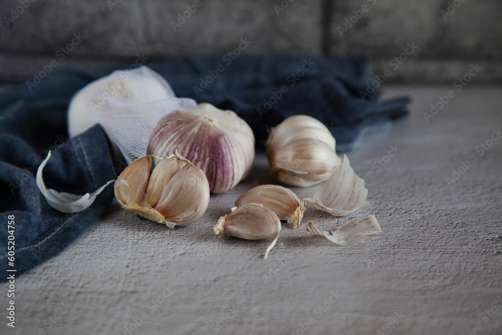 Garlic set on a gray background with a blue kitchen towel