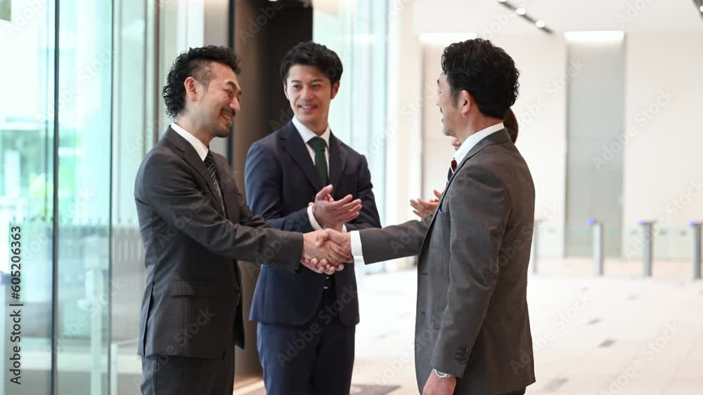 Successful business image of backlighting, shaking hands, contract signing, cooperation, etc. photo of cool Asian man in suit. Successful business image of backlighting, shaking hands, contract signing, cooperation, etc. photo of cool Asian man in suit.