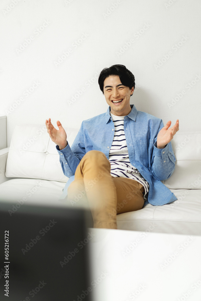 ソファに座ってテレビを見ている幸せな日本人