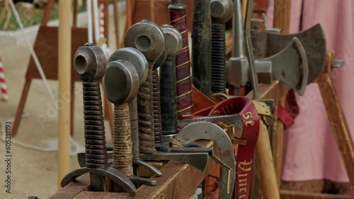 reproduction real medieval steel weapons, swords axes and spears in a rack