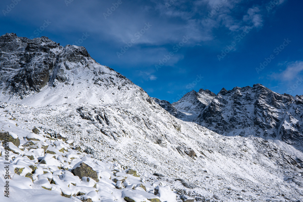 Panorama of Mountaineer standing on top of snowy mountain range at High Tatras, Slovakia
