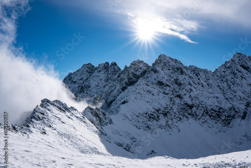Panorama of Mountaineer standing on top of snowy mountain range at High Tatras, Slovakia © Martin