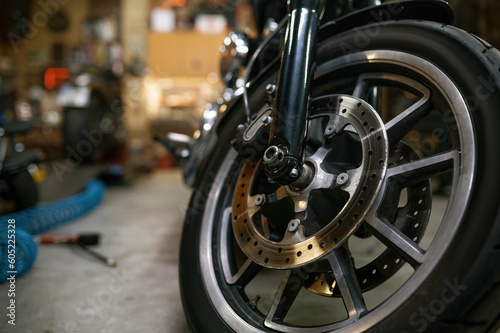 Closeup on motorcycle wheel in workshop, showroom for sale or garage service