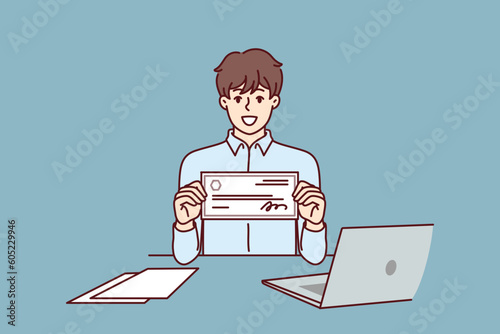 Businessman with paycheck sits at office desk with laptop showing off investments in start-ups from large corporations. Man with paycheck at his workplace demonstrates certificate for large amount