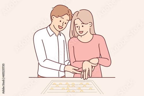 Couple newlyweds choose engagement ring in jewelry store, wanting to have wedding ceremony
