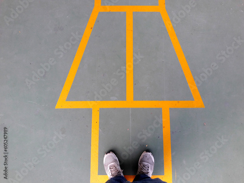 Painted yellow lines contrast against the dark asphalt and form the classic school playground game of Hopscotch photo