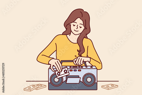 Woman inserts tape cassette into player to turn on music and start party in retro style. Happy girl with cassette recorder with smile chooses audio recording with songs from own collection 