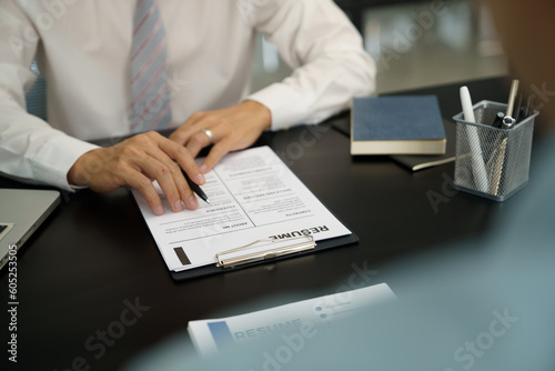 Examiner reading a resume during job interview at office Business and human resources concept.