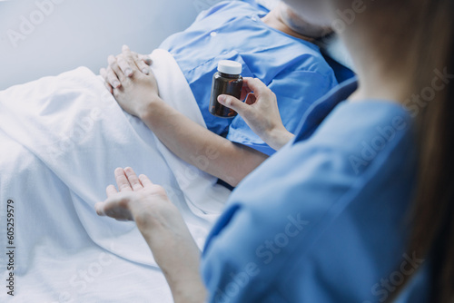 Asian caregiver doctor examine older patient use blood pressure gauge. Young woman therapist nurse at nursing home taking care of senior elderly woman sit on sofa. Medical insurance service concept