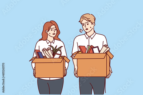 Dismissed man and woman with cardboard boxes leave workplaces after reduction of company staff due to crisis. Dismissed office workers were fired after violating corporate discipline or rules