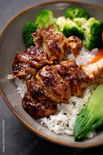Vertical closeup of delicious looking teriyaki chicken with rice and fresh herbs