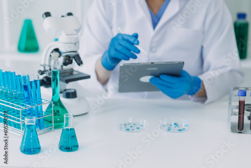 biochemical research scientist team working with microscope for coronavirus vaccine development in pharmaceutical research labolatory, selective focus