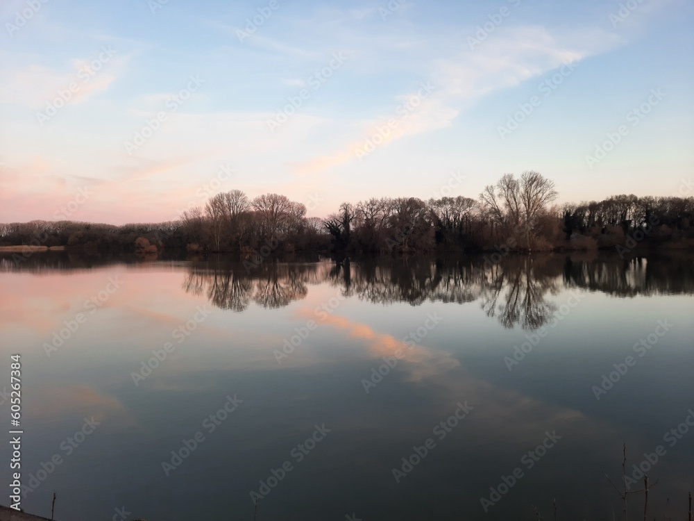 A river with a pink sky and a few clouds