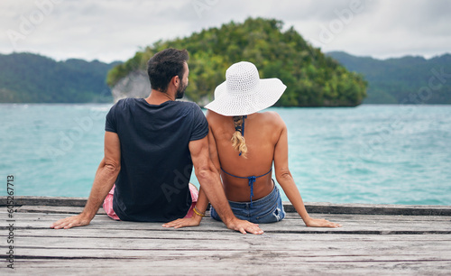 Foto Back, couple and vacation together on ocean deck, dock or sitting on boardwalk to relax or enjoy the sea or water landscape