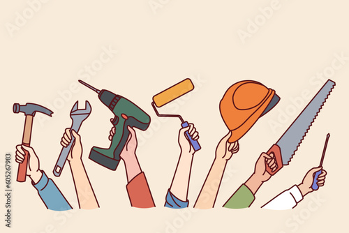 Hands of repair and construction specialists with working tools for safe and efficient work. Screwdriver and hammer with safety helmet in hands of furniture repair or building construction workers