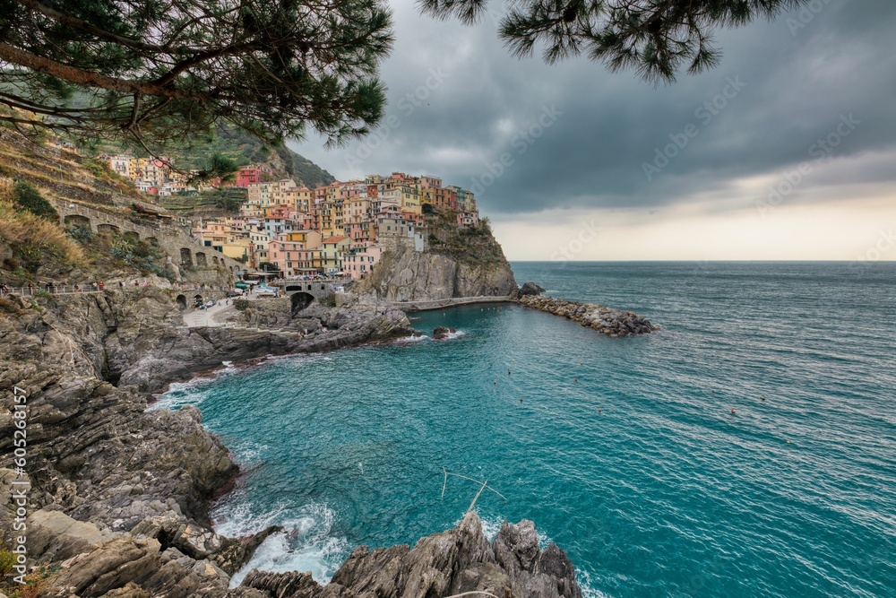 Scenic vista of tranquil blue water with small houses on a shoreline ciff in Manarola, Cinque Terre
