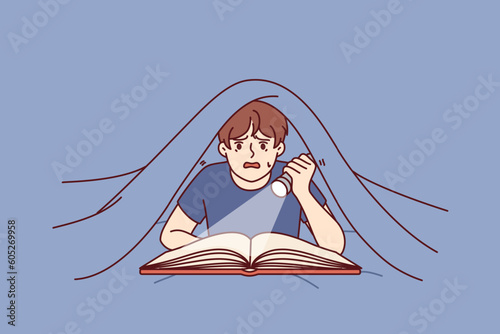 Boy with flashlight reads book lying under covers and is frightened by story described in fictional novel. Frightened boy with book enjoys reading fantasy literature in secret from parents