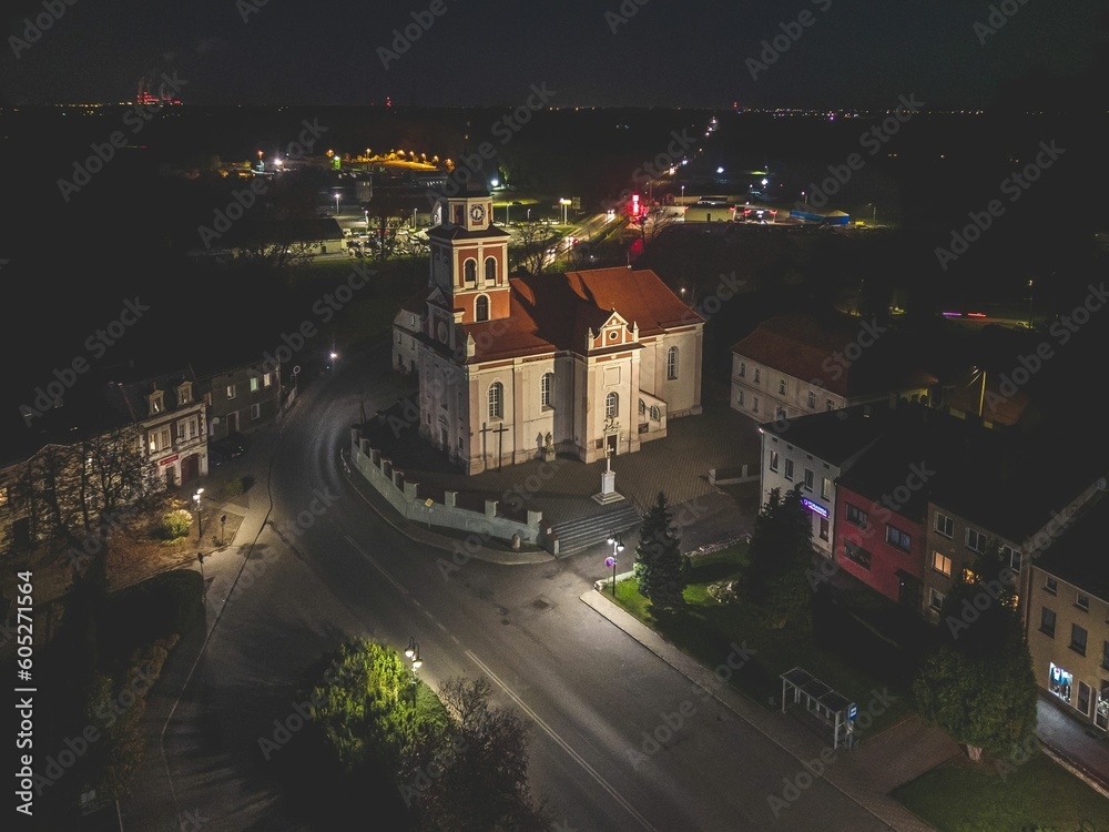 Aerial view of a quaint old church illuminated at night in Proszkow, Poland