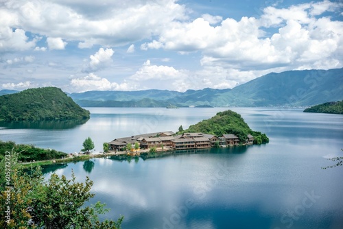Fototapeta Naklejka Na Ścianę i Meble -  Beautiful view of a peninsula in Lugu lake under a blue sky with clouds in China.