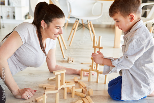 Mother and son play with wooden building blocks