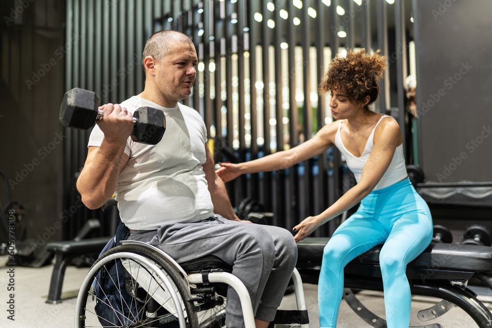 In a display of strength and inclusivity, a person in a wheelchair engages in a workout session with the help of a supportive female fitness instructor.
In a display of strength and inclusivity, a person in a wheelchair engages in a workout session with the help of a supportive female fitness instructor.
