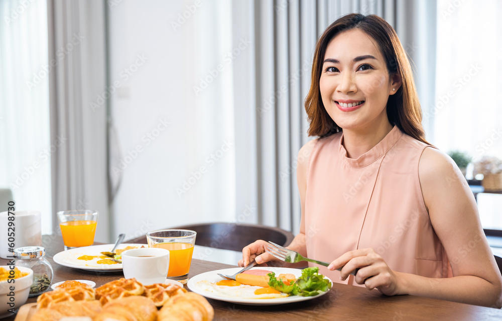 Woman eat fresh breakfast served food with beverage before go to work in the morning at home, Asian young female sitting kitchen table food having eating healthy breakfast at home