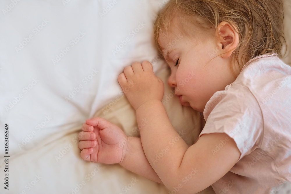 Peaceful adorable baby sleeping on his bed at home. Sleeping newborn baby concept. One year old baby girl sleeps peaceful at domestic room interior background. Serene dream. Cute Face Close Up Peaceful adorable baby sleeping on his bed at home. Sleeping newborn baby concept. One year old baby girl sleeps peaceful at domestic room interior background. Serene dream. Cute Face Close Up