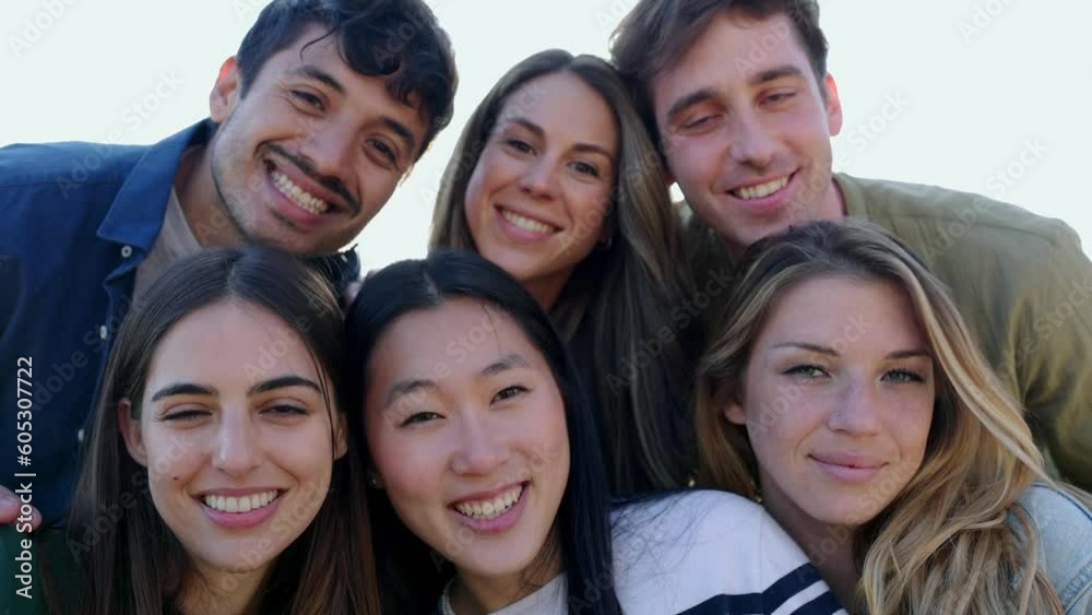 Diverse group portrait of friends smile at camera outdoors. Multiethnic young people having fun together. Millennial men and women enjoying summer travel. Friendship and youth community concept. Diverse group portrait of friends smile at camera outdoors. Multiethnic young people having fun together. Millennial men and women enjoying summer travel. Friendship and youth community concept.