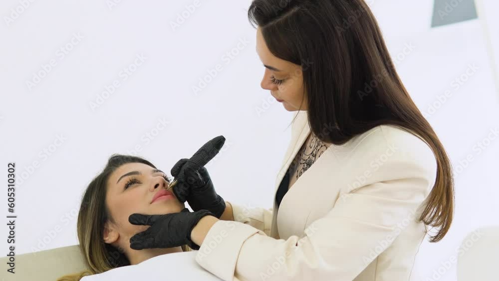 Process woman applying permanent tattoo makeup on lips in beautician salon Process woman applying permanent tattoo makeup on lips in beautician salon