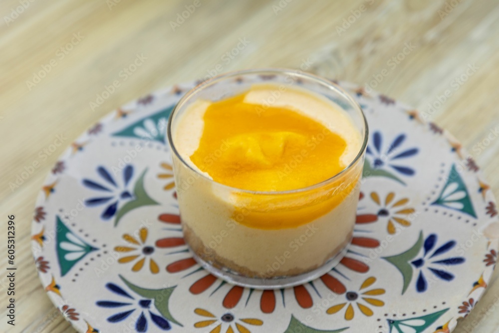 Close-up shot of sweet Panna Cotta in colorful plate on a wooden table Close-up shot of sweet Panna Cotta in colorful plate on a wooden table