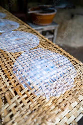 Fresh made ricepaper is drying on bamboo table for production of dumplings and spring rolls in the Cu Chi tunnels. Famous tourist attraction in Vietnam. Stock photo photo